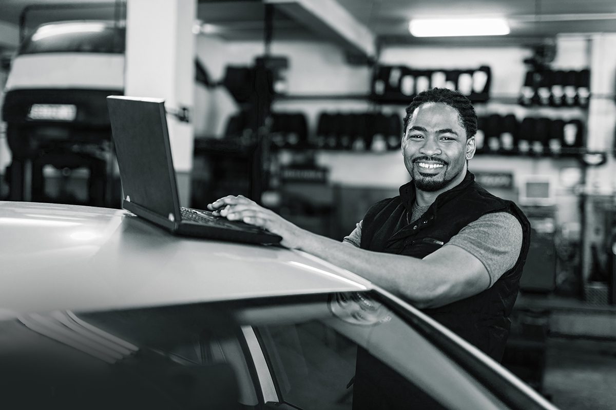 automotive professional uses online materials to research in a car repair shop
